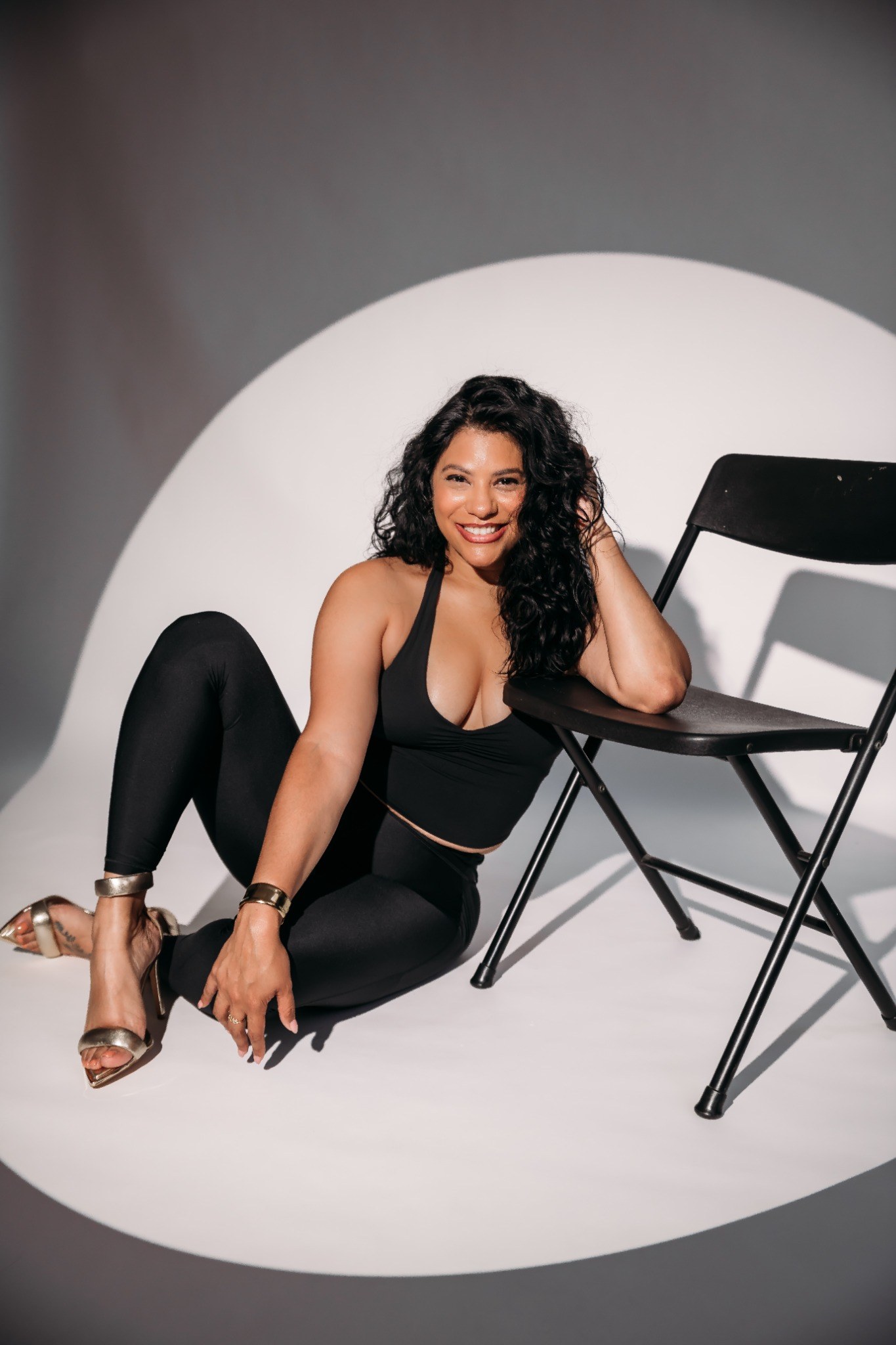 Shay smiling beside a chair during a chair dance photoshoot.