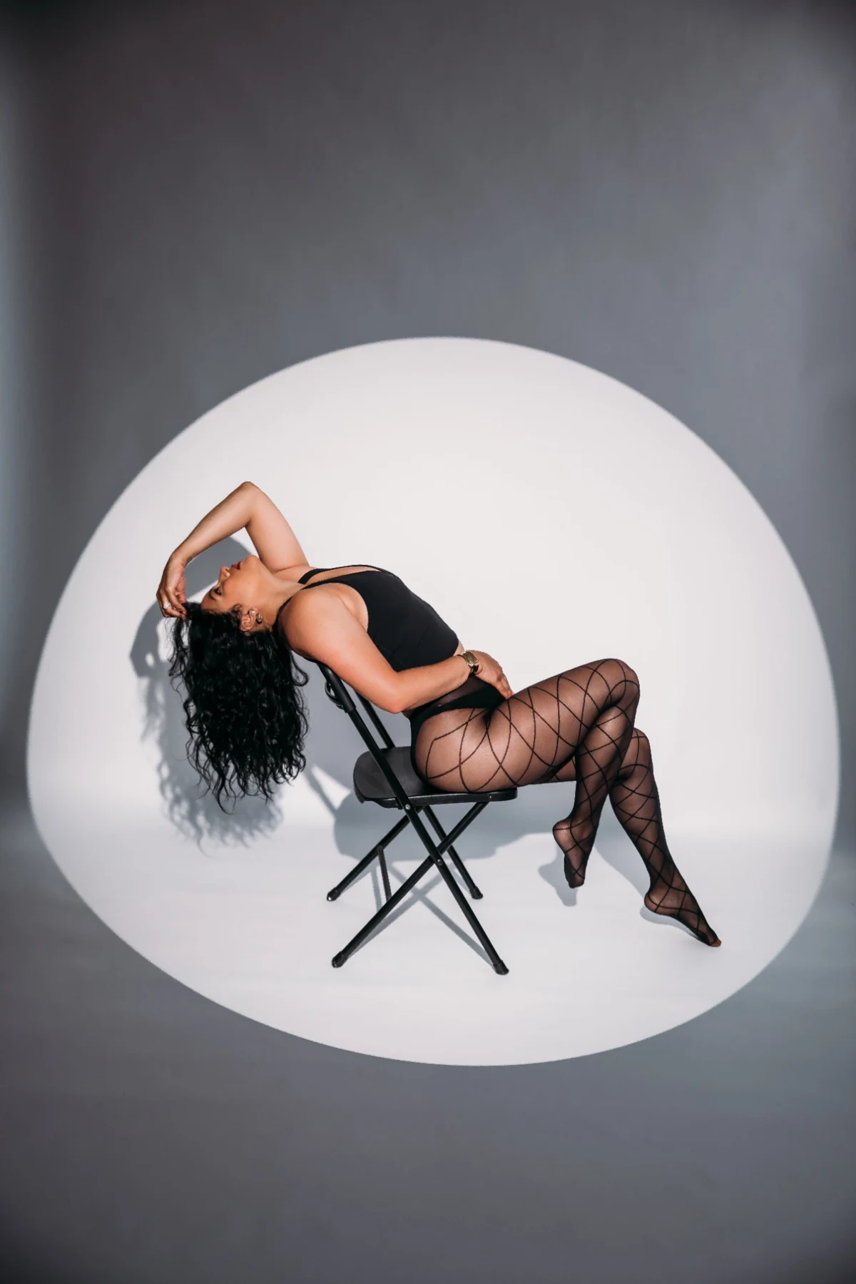 Shay reclining in a studio chair dance pose